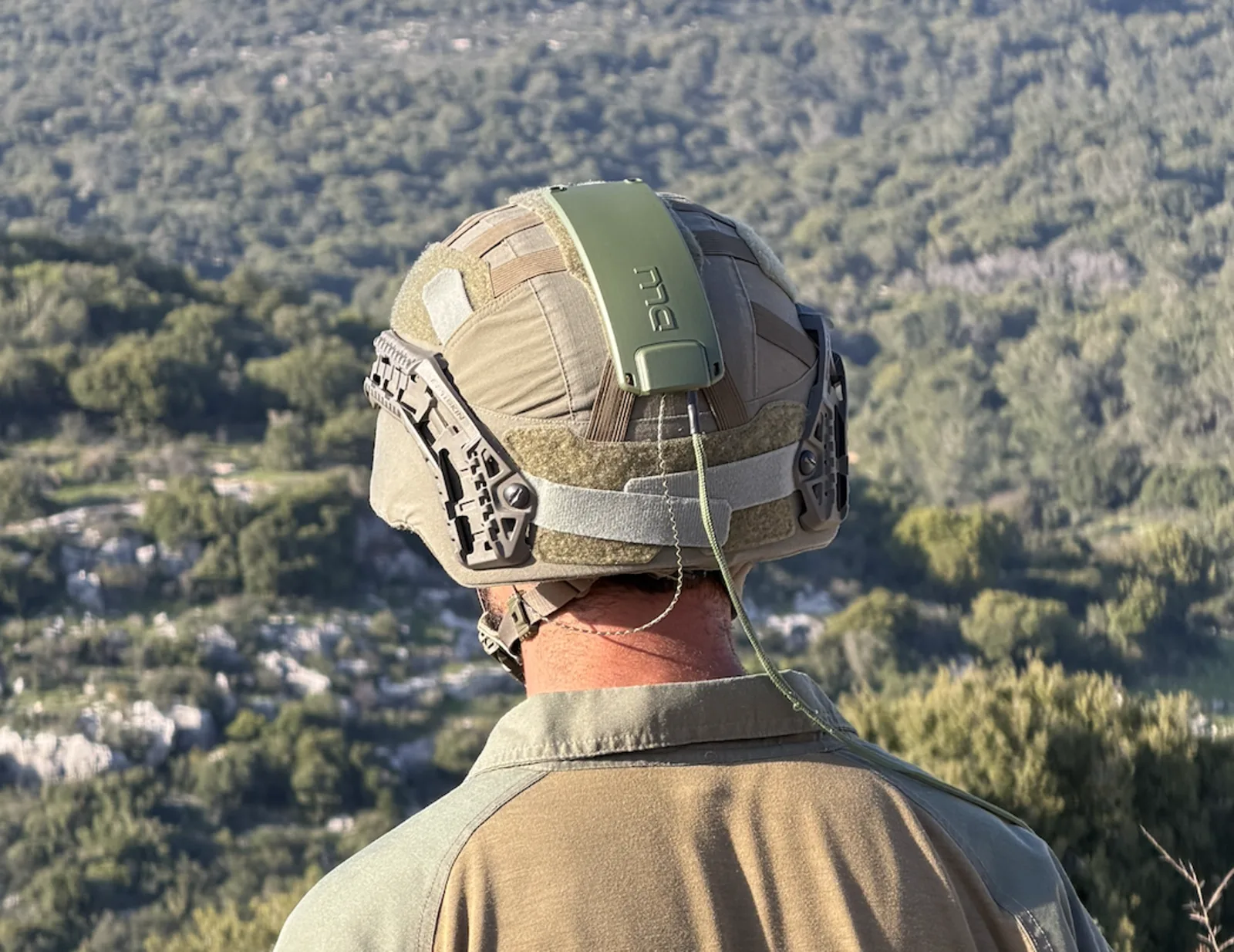 DLU module mounted on tactical helmet, operator viewing terrain